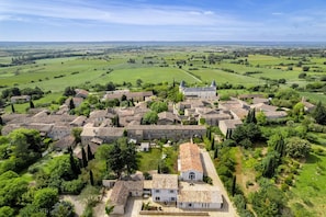 A historic village with stone buildings, a church, and a castle in the background.