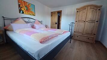 Ein Schlafzimmer mit einem Bett, einem Holzschrank und einem Gemälde an der Wand.