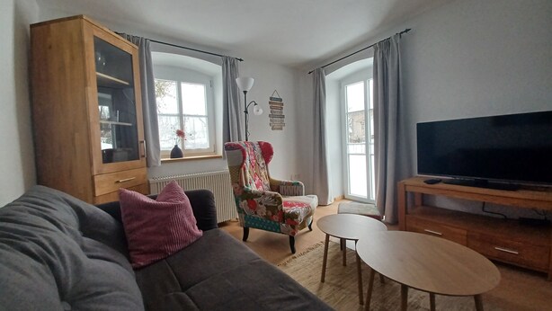 A living room with a sofa, a chair, a small table, a television, and a cabinet. - Feel-good place in the heart of Pfaffenwinkel:Freshly renovated with its own terrace (Rottenbuch)