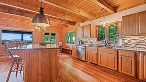 Une cuisine spacieuse avec des meubles en bois, un îlot central et de grandes fenêtres.
