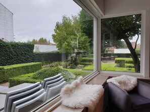 Enjoy a serene view of the well-maintained garden from the large window in this stylish room.