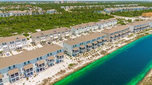 Zona residencial costera con edificios de varios pisos, acceso directo a la playa y vista despejada del océano.