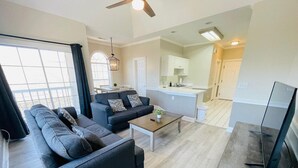 Una sala moderna con un conjunto de sofás, una mesa de centro y un televisor.