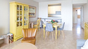 Un'area pranzo con un armadietto giallo, un tavolo con sedie e un lampadario.