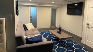 A modern living room with a sofa, a coffee table, and a patterned rug.