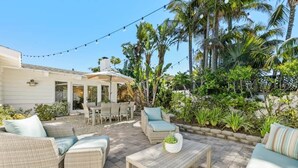 An outdoor patio with wicker furniture, a dining area, and a stone pathway. - Across the street from the beach with Pool and Spa (Solana Beach)