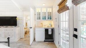 A modern kitchen with white cabinetry, a built-in oven, and a window with a view.