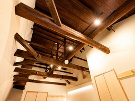 Una habitación con vigas de madera a la vista y un techo alto.