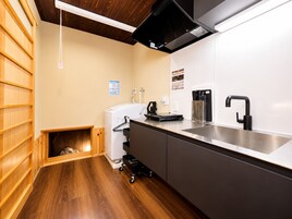 Una cocina moderna con un lavamanos de acero inoxidable, una cafetera y un horno empotrado.
