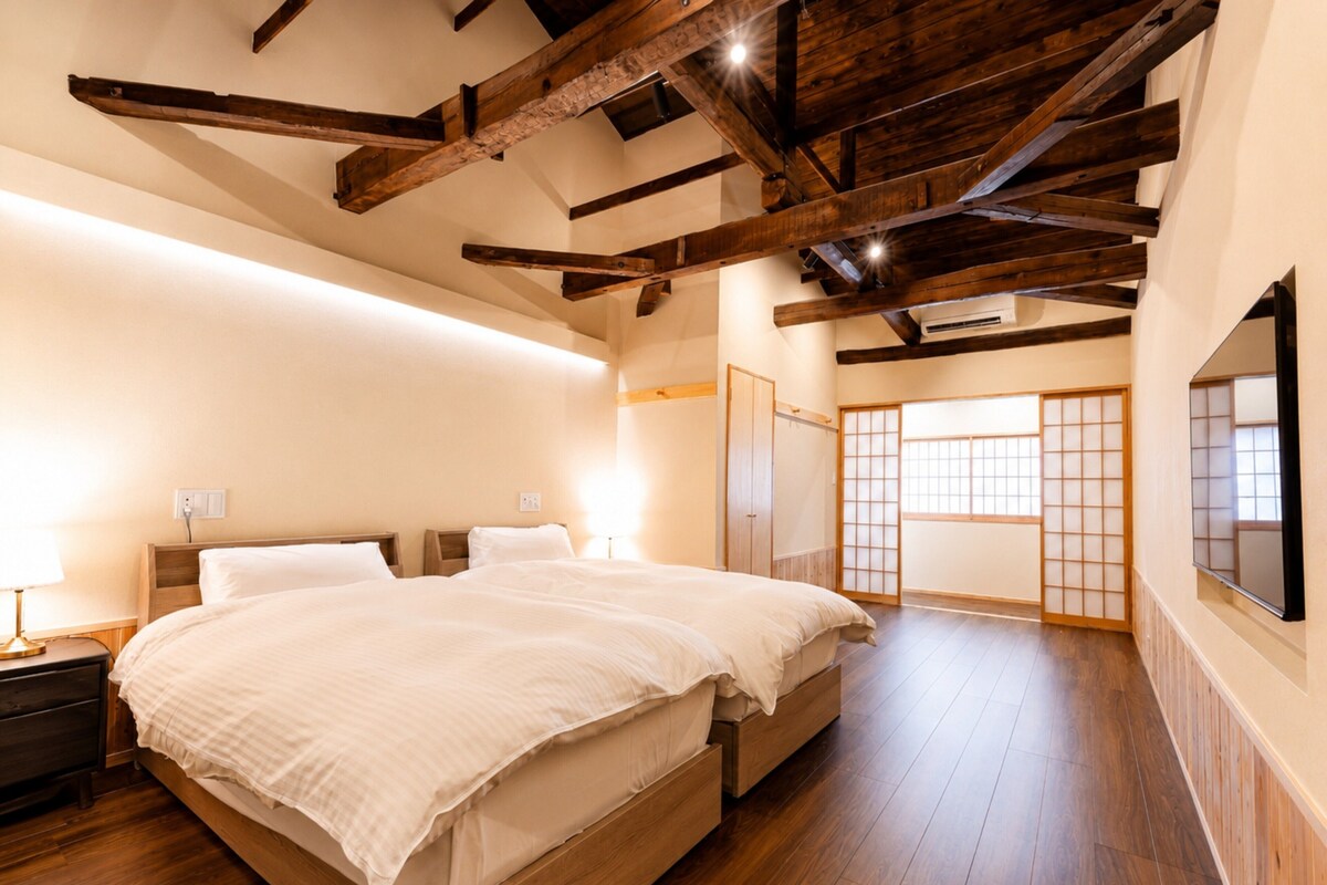 A bedroom with a wooden bed, bedside tables, a wardrobe, and a sliding door with a view.