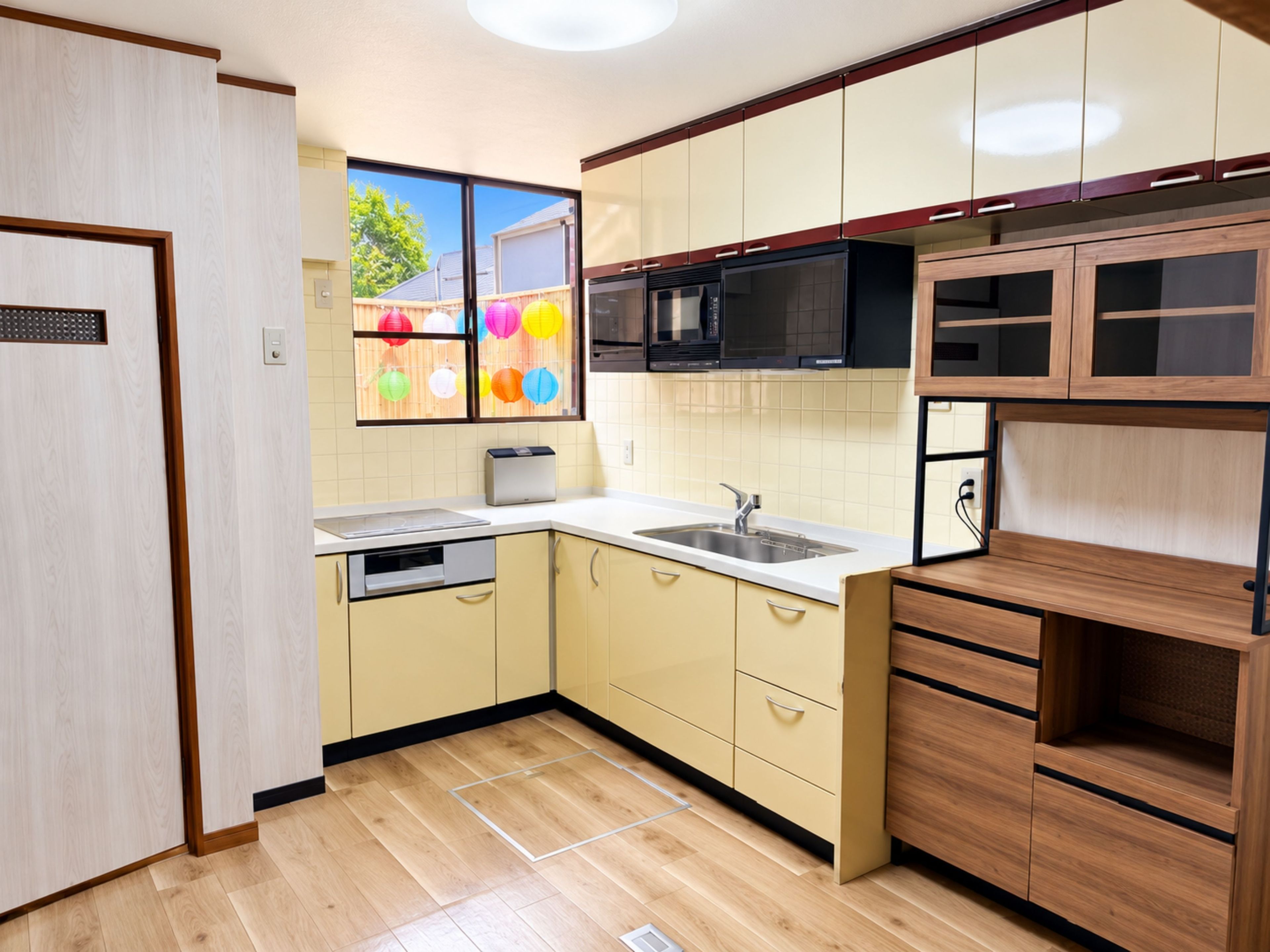 Une cuisine moderne avec des meubles en bois, un four à micro-ondes, un évier et une fenêtre donnant sur un jardin.