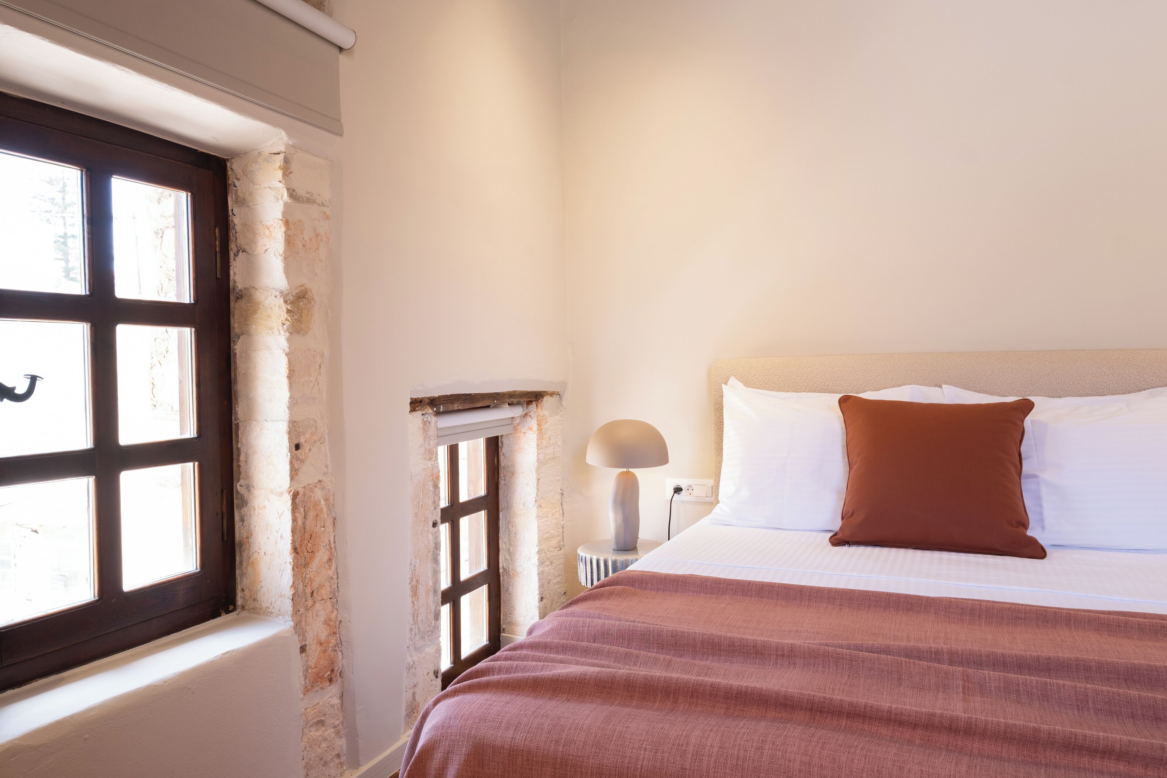 A bedroom with a bed, a window, and a lamp.