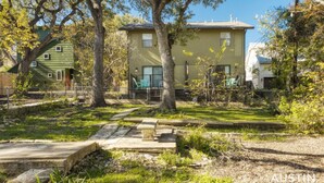 A residential area with a two-story house, a fenced yard, and a stone bench. - Ravey #B xxxxxxxxxxx (Austin)