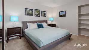 A bedroom with a bed, two bedside tables, a ceiling fan, and wall-mounted shelves. - Ravey #B xxxxxxxxxxx (Austin)