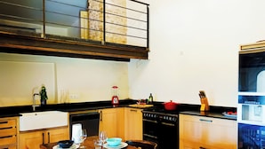 Une cuisine équipée d’une table à manger, de chaises, d’une cuisinière et d’un réfrigérateur.