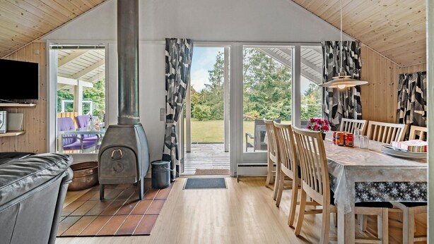 A cozy cabin interior with a dining area, a fireplace, and a television. - Cozy home in Fårvang with WiFi (Fårvang)