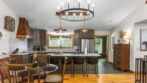 Une cuisine moderne avec un îlot central, des chaises en bois et une table à manger.
