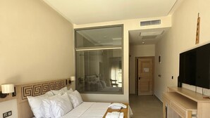 A hotel room with a bed, a TV, a desk, and a window with a view. - Etruscan Boutique Hotel (Eceabat)