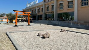 A hotel with a modern facade, a prominent entrance, and a traditional Japanese torii gate. - Etruscan Boutique Hotel (Eceabat)
