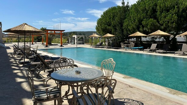 A pool area with lounge chairs, umbrellas, and a pergola. - Etruscan Boutique Hotel (Eceabat)