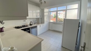 Een koffiezetapparaat/waterkoker, een koelkast, een oven, een kookplaat