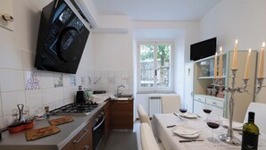 A kitchen with a stove, sink, and dining area set for a meal. - Exclusive  apartment in Perugia centre with parking  (perugia)