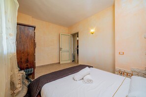Una camera da letto con un letto, un armadio in legno, una porta e una lampada a parete.