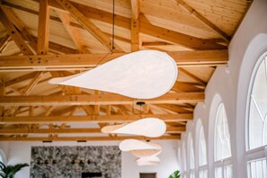 A room with wooden beams, large windows, and hanging pendant lights. - Secret d'Uzès - The Loft, with heated pool (Aubussargues)