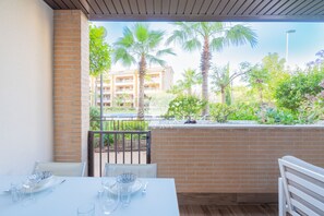 Mesa lista para comer con vista a palmeras y un edificio al fondo.