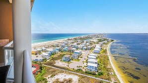 A coastal residential area with houses, a beach, and a pier.