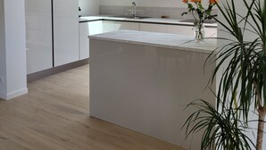A modern kitchen with a skylight, wooden cabinets, and a central island. - Maison de Vacances à 2 pas de la Plage et des Commerces (Pornic)