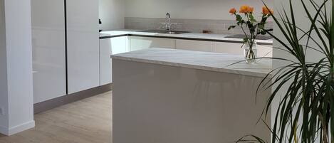 A modern kitchen with a skylight, wooden cabinets, and a central island.