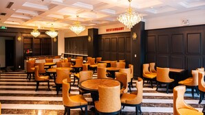 A restaurant with a checkered floor, multiple chandeliers, and a bar area. - Solis Hotel (Hai Phong)