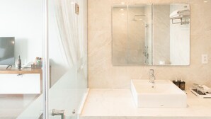 A modern bathroom with a glass shower enclosure, a large mirror, and a white sink. - Solis Hotel (Hai Phong)