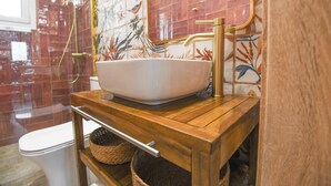 A bathroom with a white vessel sink, a wooden vanity, and a shower with a glass door. - Vivis Hub (Kefalonia)