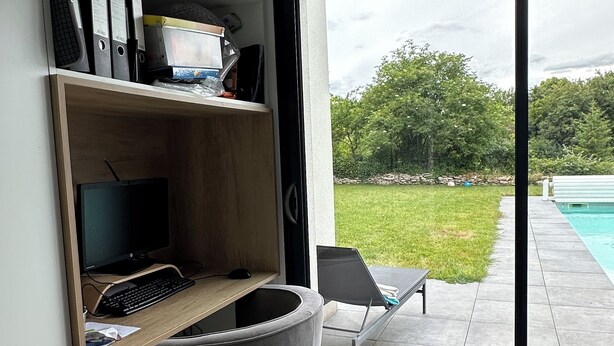 Un espacio de oficina moderno con escritorio, computadora y estanterías.