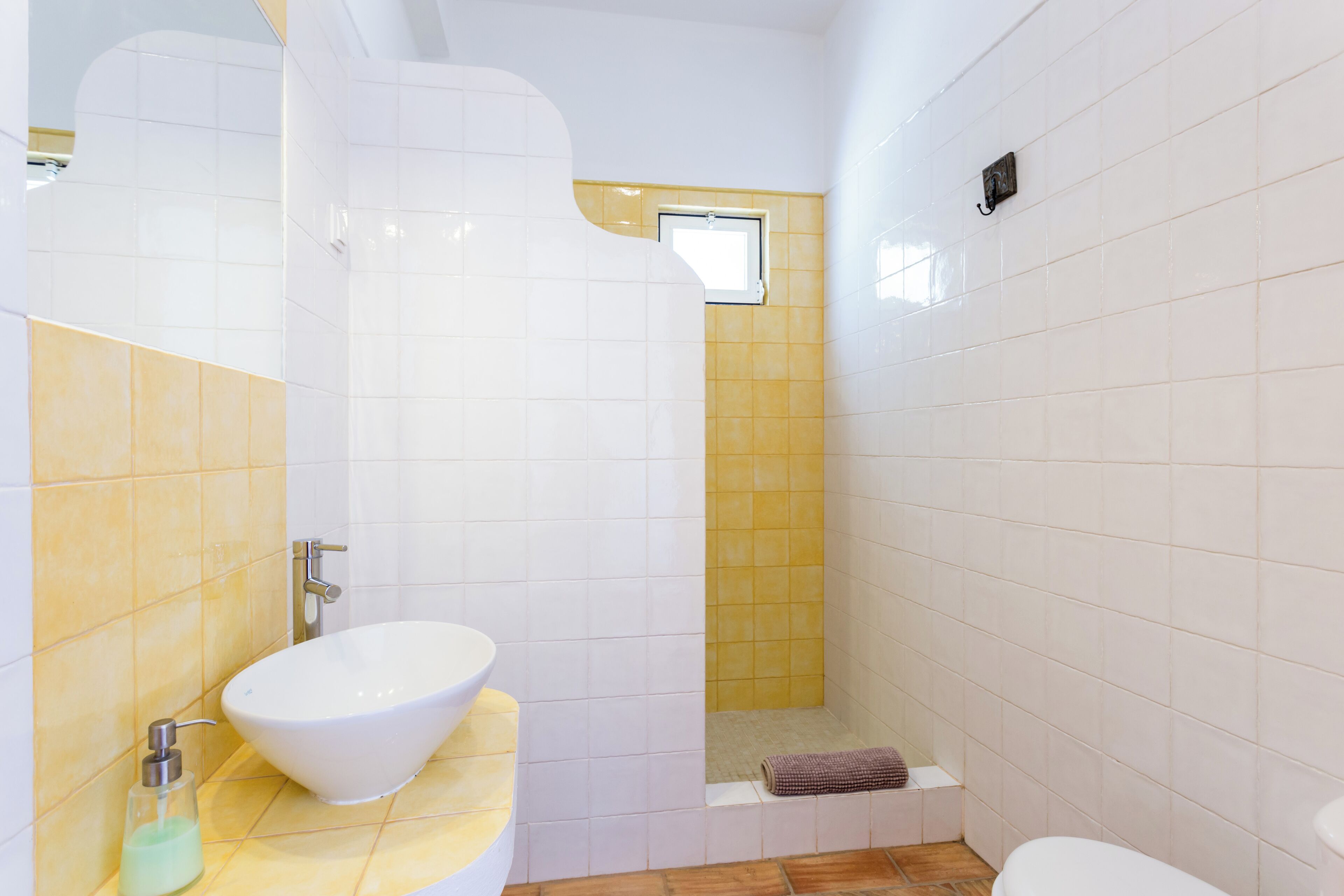 A bathroom with a white sink, a shower, and a toilet.