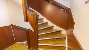 A wooden staircase with a handrail, wooden steps, and a white wall. - Travel (Amsterdam)