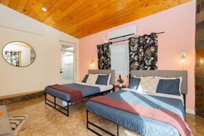 A bedroom with two beds, a mirror, an air conditioning unit, and a window with curtains. - Iconic & Private 4BR: Walkable to Las Vegas Strip (Las Vegas)