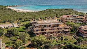 Ein Küstenresort mit mehreren Gebäuden, einem Strand und Blick aufs Meer.
