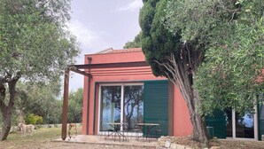 Un edificio moderno con facciata rossa, ampie finestre e posti a sedere all'aperto.