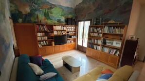 Un salon comprenant un canapé, une table basse et des étagères remplies de livres.