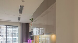 A modern kitchen with a large window, a dining area, and a view of the cityscape. - The Tresor Apartment Quan 4 (Ho Chi Minh City)