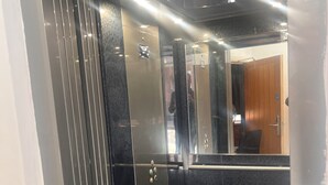 An elevator with metallic doors and a control panel. - Tumbledown Hotel (Shrewsbury)