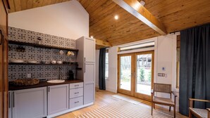 Eine moderne Küche mit gemusterten Spritzschutz, Holzboden und Blick ins Freie.