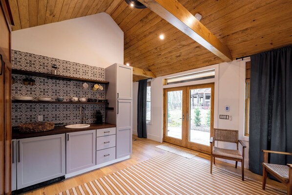 Una cocina moderna con un salpicadero estampado, techo de madera y vistas al exterior.