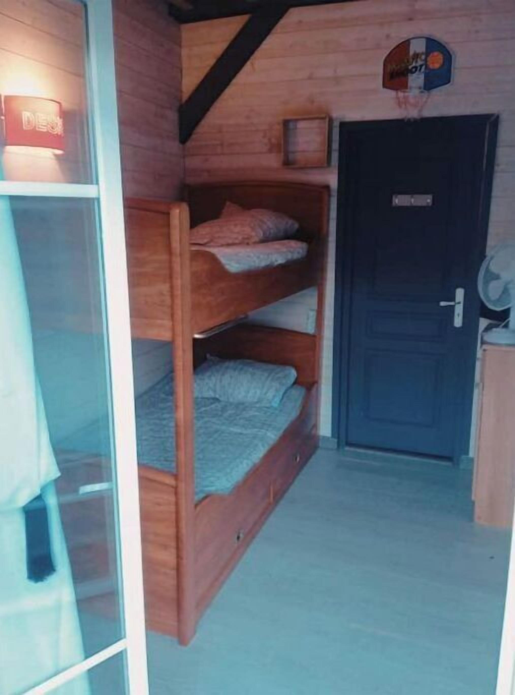 A room with a bunk bed, a door, and a small window.