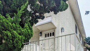 Ein Gebäude mit weißer Fassade, einem verschlossenen Eingang und einem kleinen Balkon.