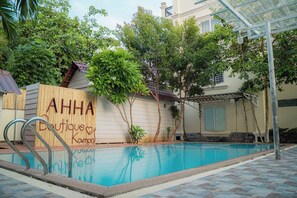 Una piscina al aire libre, sombrillas, sillones reclinables de piscina