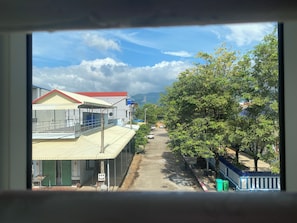 A street view with buildings, a clear sky, and a distant mountain range. - AHHA Boutique Kampot (Kampot)